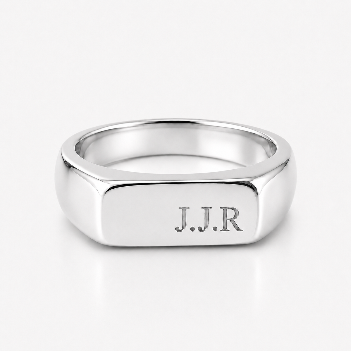 A polished silver signet ring with the engraved initials 'J.J.R' on the face, shown on a clean white background.