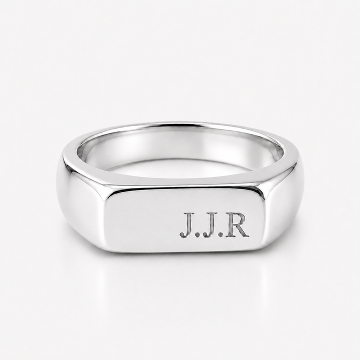 A polished silver signet ring with the engraved initials 'J.J.R' on the face, shown on a clean white background.