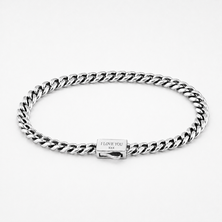 A silver-toned metal curb link bracelet with a rectangular clasp engraved with 'I LOVE YOU xxx', shown on a clean white background.