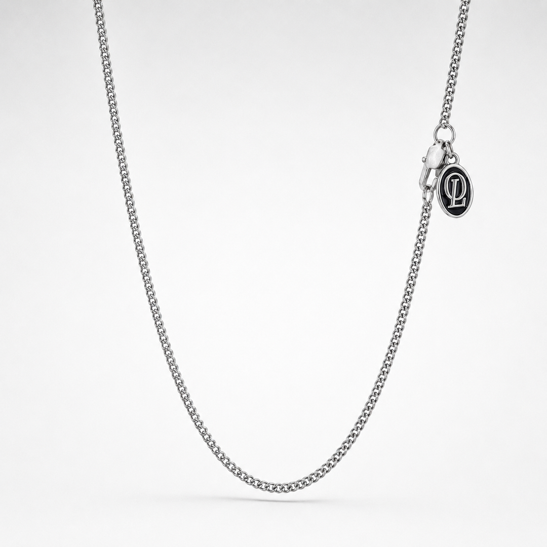Silver chain necklace on a light gray background