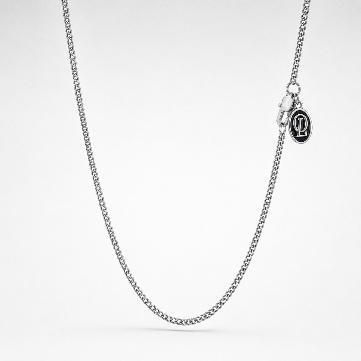 Silver chain necklace on a light gray background