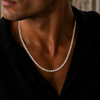 A close-up of a man wearing a classic white pearl necklace with a black shirt, highlighting the necklace against his neck.