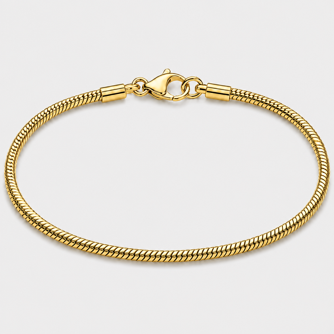 A gold-toned metal chain bracelet with a lobster clasp, shown in a circular loop on a light gray background.