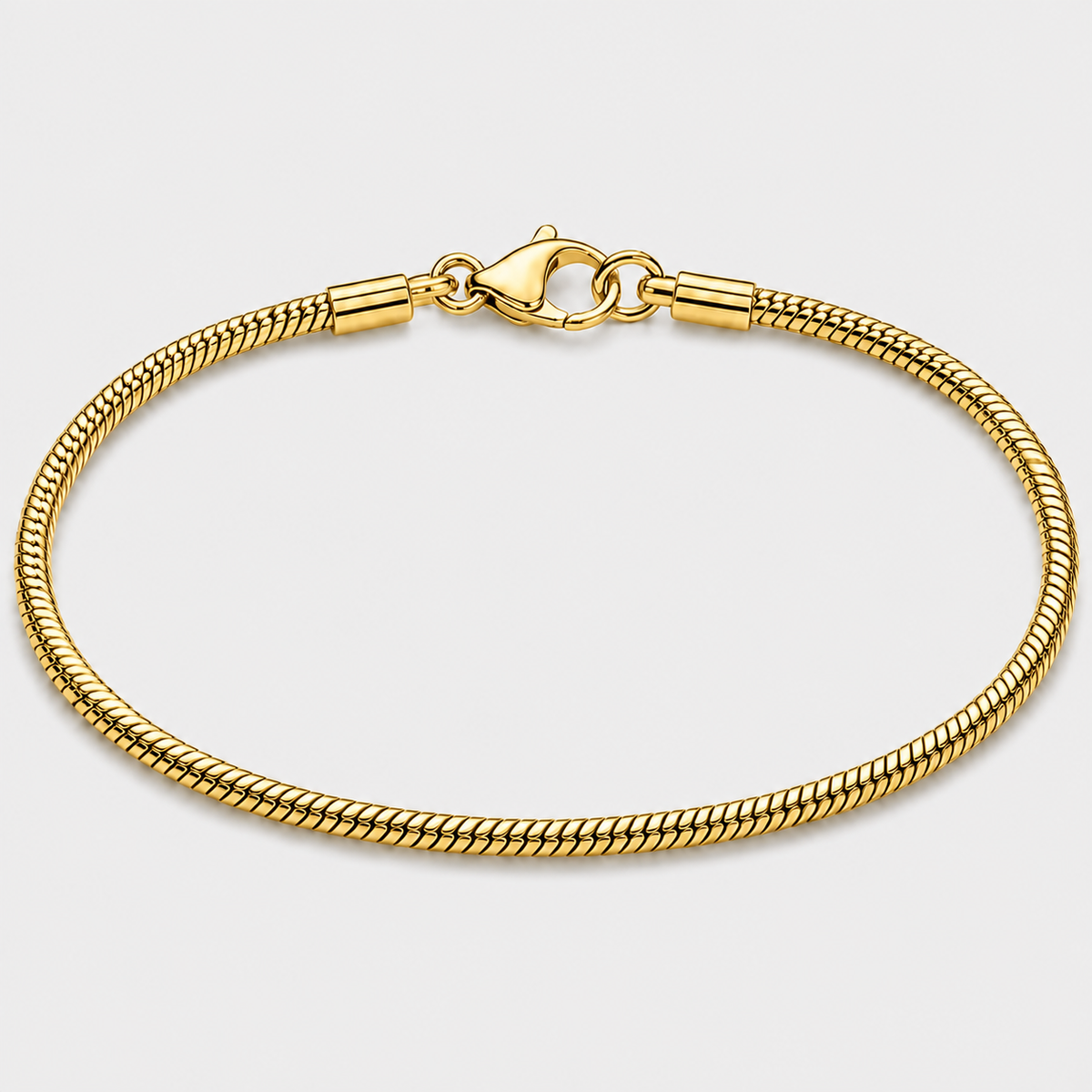 A gold-toned metal chain bracelet with a lobster clasp, shown in a circular loop on a light gray background.