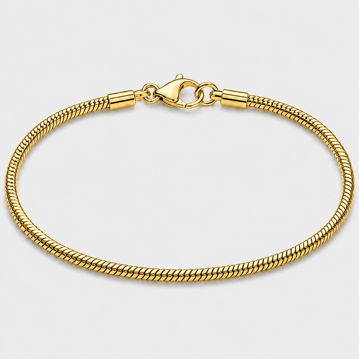 A gold-toned metal chain bracelet with a lobster clasp, shown in a circular loop on a light gray background.