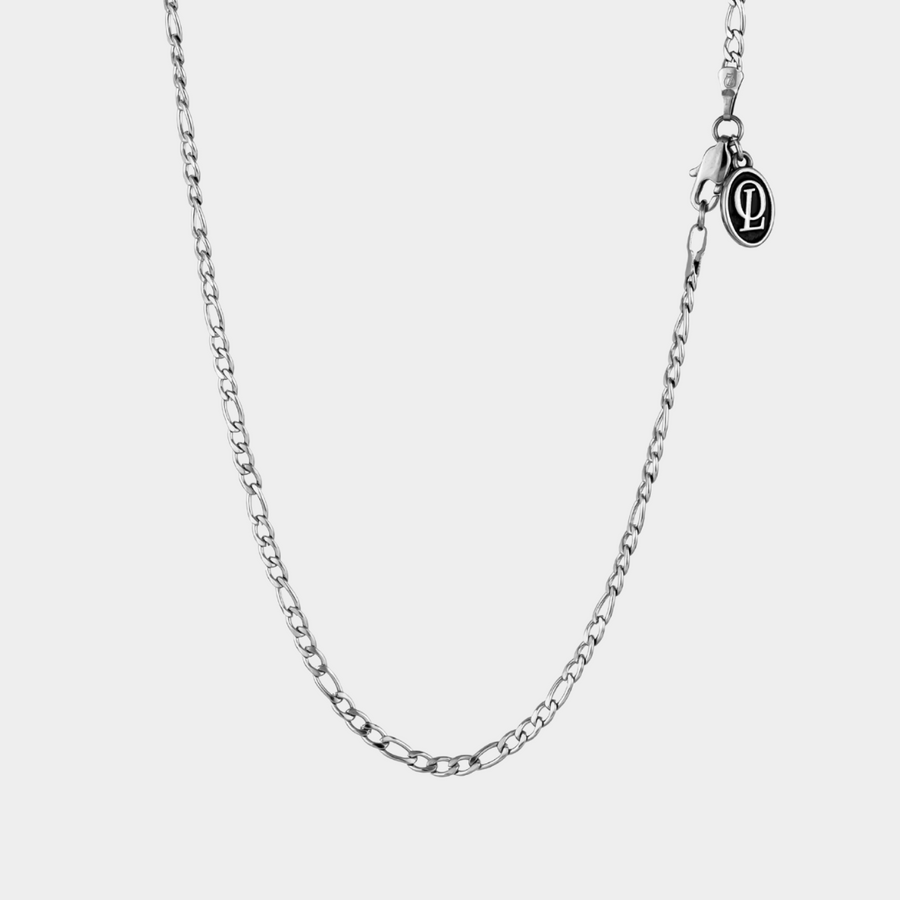 Silver chain necklace on a light gray background