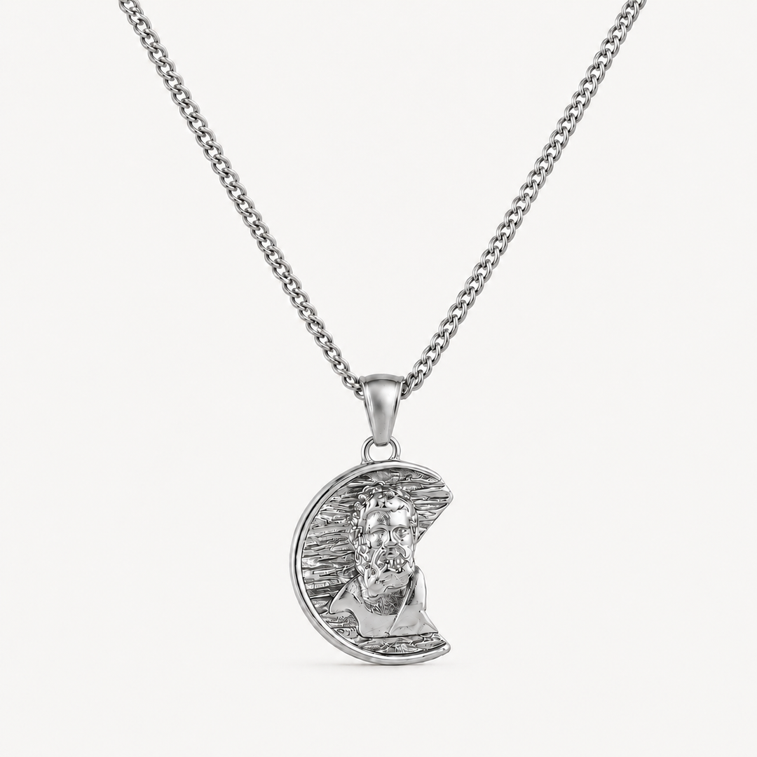 A silver pendant necklace featuring a crescent moon with a detailed portrait of Jesus Christ, suspended from a classic curb chain against a clean white background.