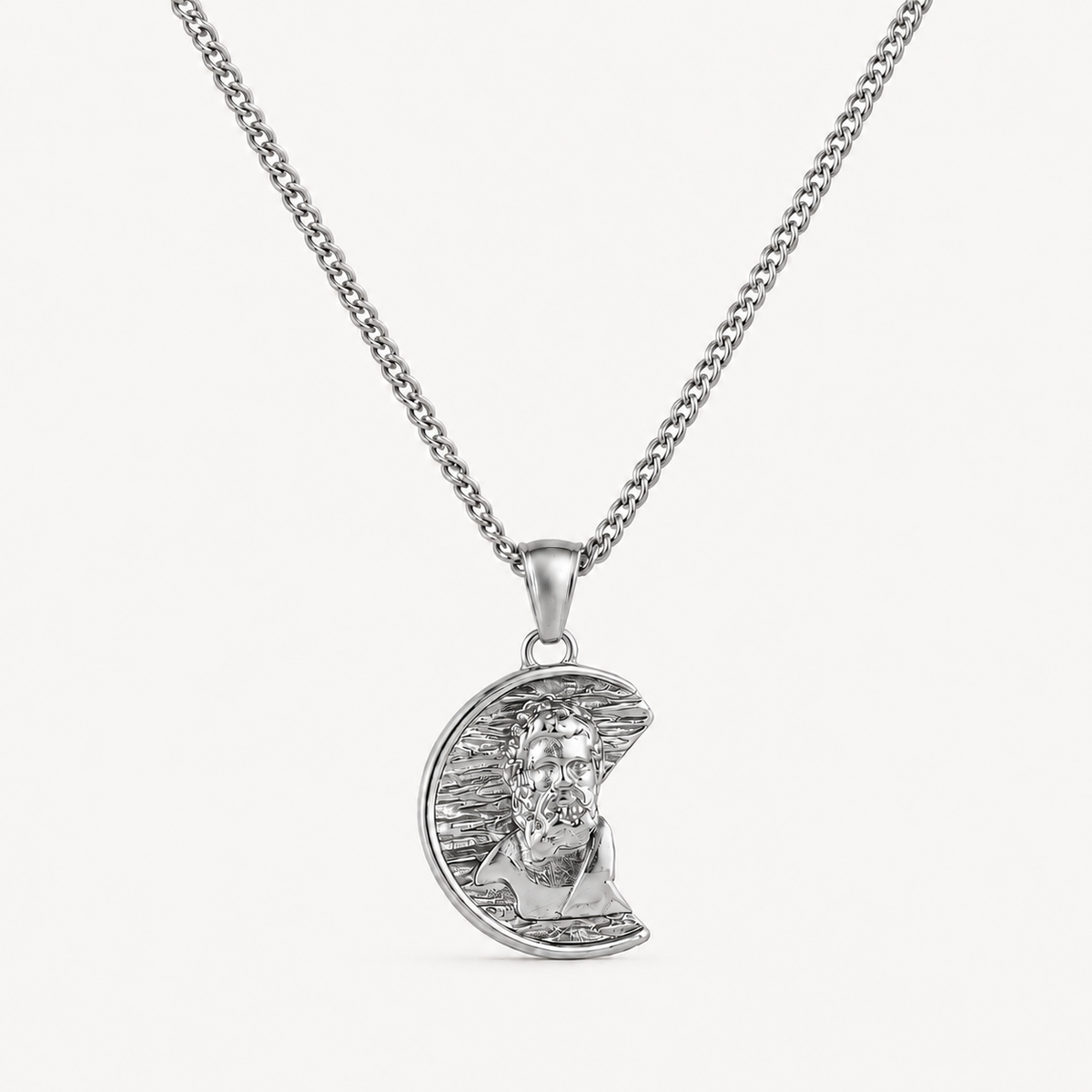 A silver pendant necklace featuring a crescent moon with a detailed portrait of Jesus Christ, suspended from a classic curb chain against a clean white background.