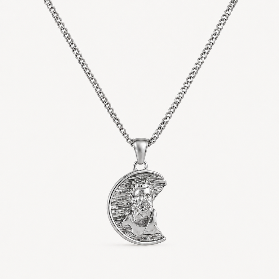 A silver pendant necklace featuring a crescent moon with a detailed portrait of Jesus Christ, suspended from a classic curb chain against a clean white background.