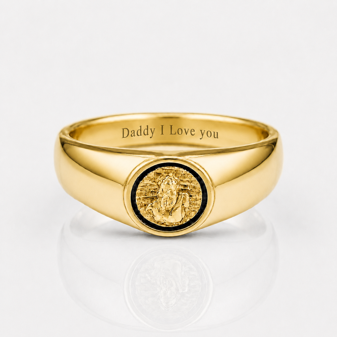 A polished gold signet ring engraved with 'Daddy I Love you' inside the band, featuring a circular gold medallion with a black inlay on the face, set against a clean white background with a soft reflection.