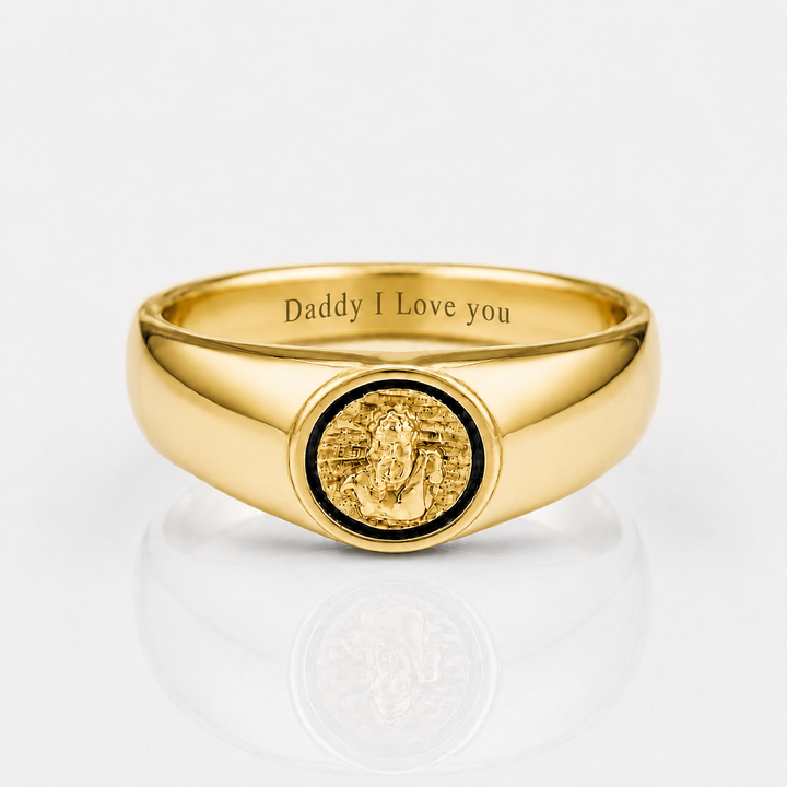A polished gold signet ring engraved with 'Daddy I Love you' inside the band, featuring a circular gold medallion with a black inlay on the face, set against a clean white background with a soft reflection.