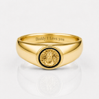 A polished gold signet ring engraved with 'Daddy I Love you' inside the band, featuring a circular gold medallion with a black inlay on the face, set against a clean white background with a soft reflection.