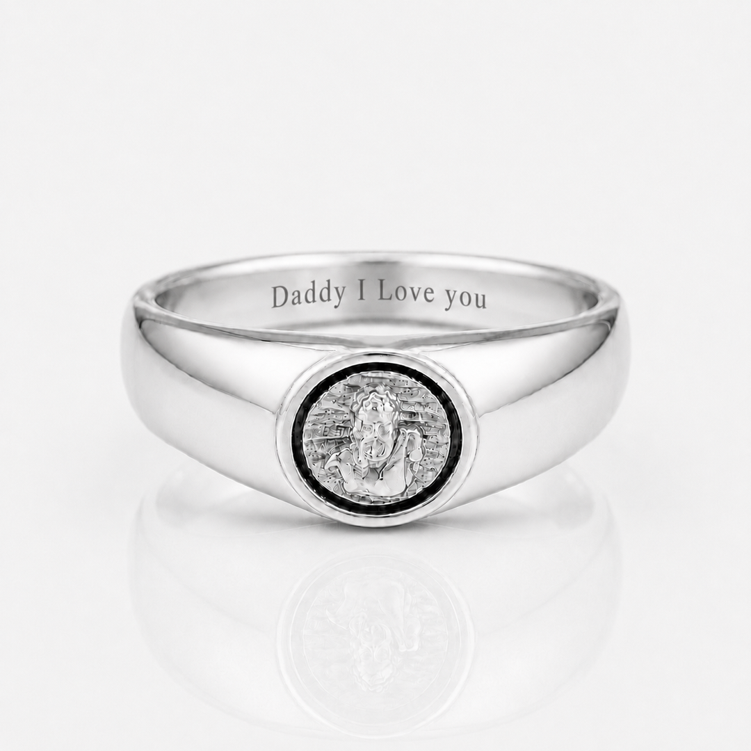 A polished silver signet ring engraved with 'Daddy I Love you' on the inside band, featuring a circular medallion with a silver statue of Lord Ganesha in the center, set against a clean white background with a soft reflection.