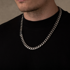 Man wearing a silver chain necklace against a neutral background