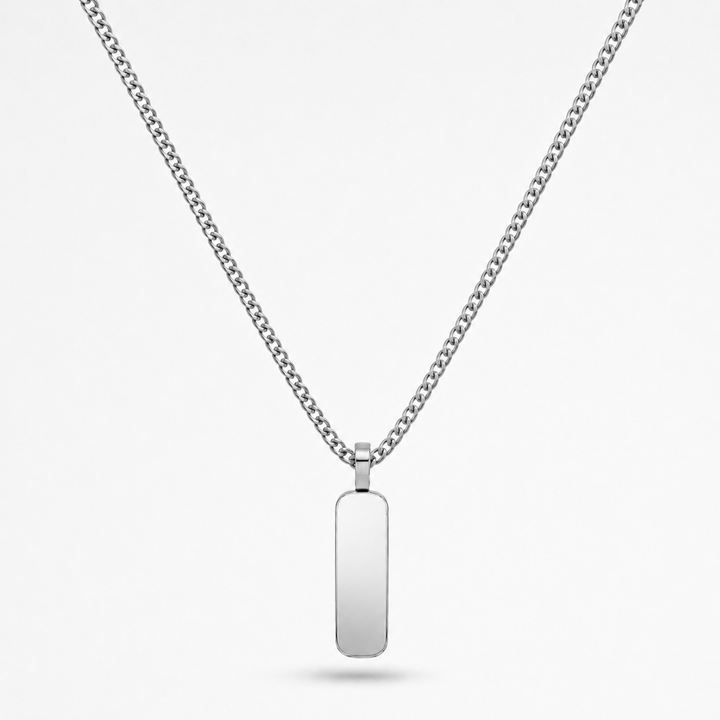 A silver-toned stainless steel chain necklace with a flat, polished rectangular dog tag pendant, shown against a light gray background.