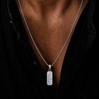 A silver rectangular pendant necklace with engraved text, worn on a model's neck over a black shirt.