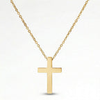 A gold cross pendant necklace against a white background.