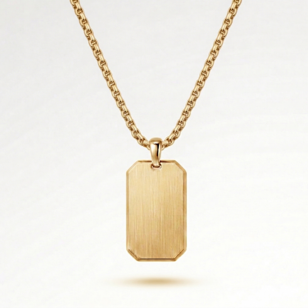 A gold-colored necklace with a rectangular pendant hanging from a chain.