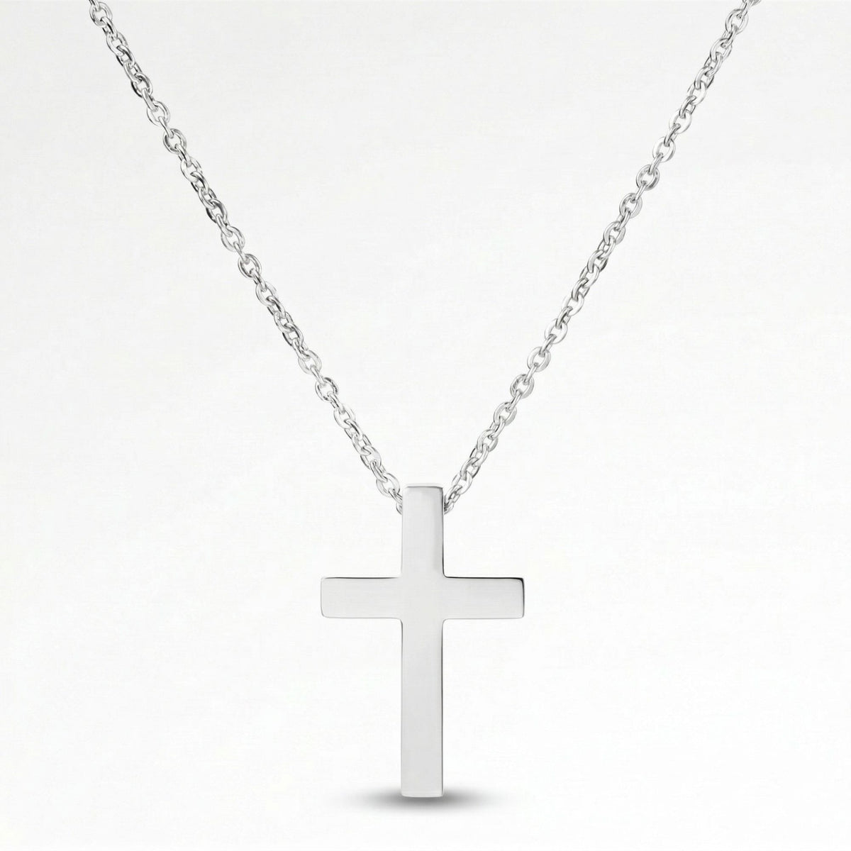 A silver cross pendant necklace against a white background.