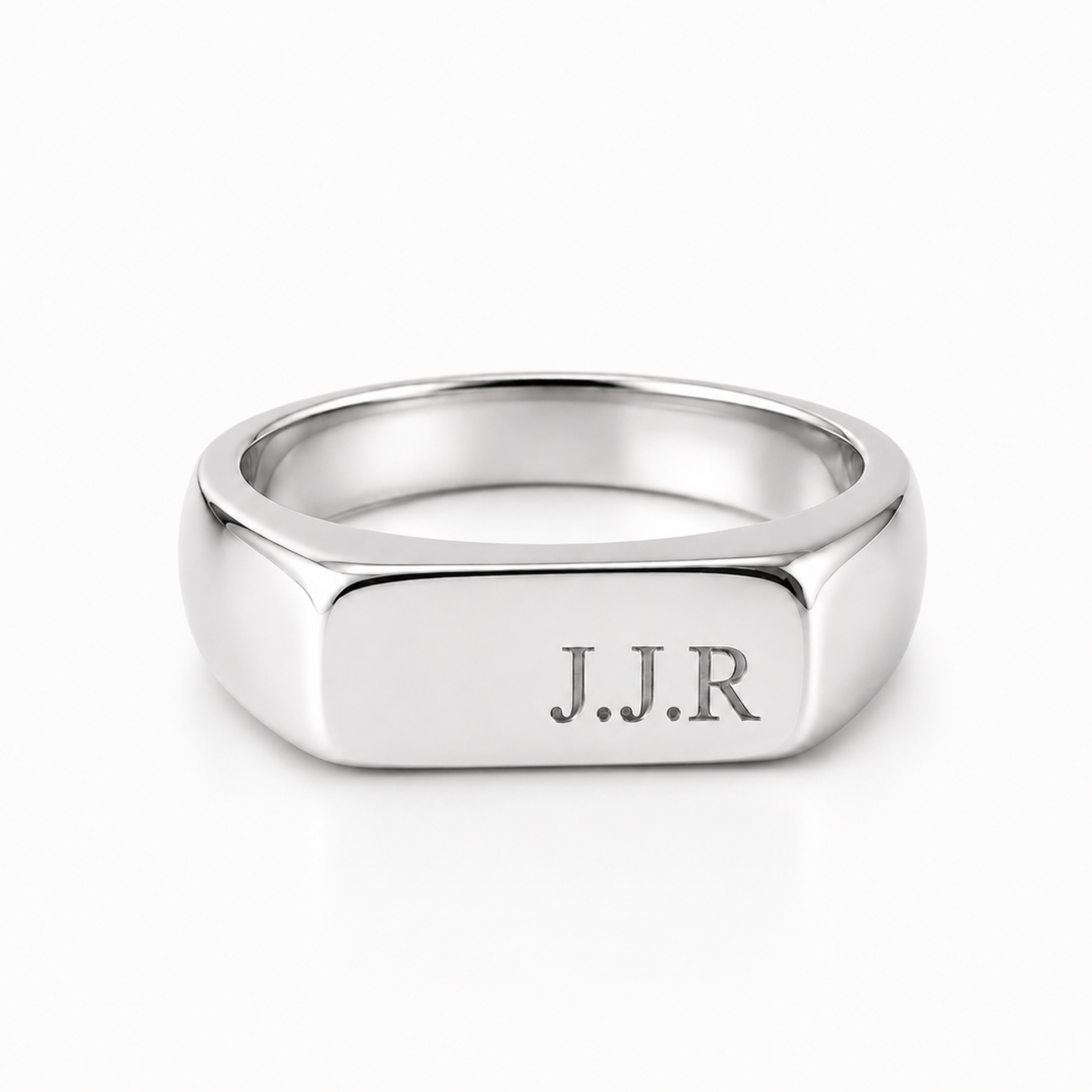 A silver-toned signet ring with a polished hexagonal face engraved with the initials 'J.J.R'